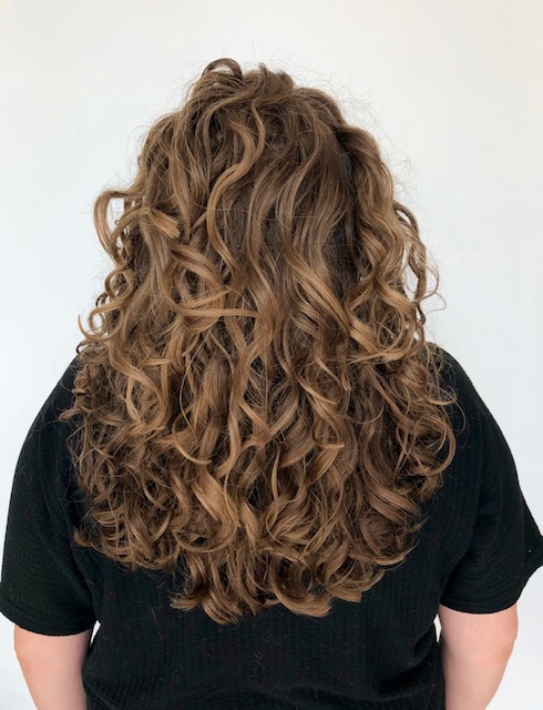 This is a photo of a young woman who had their hair colored a gorgeous rich caramel color and who she also added hair extensions for volume and length at Beautify Salon and Spa in Henderson Las Vegas