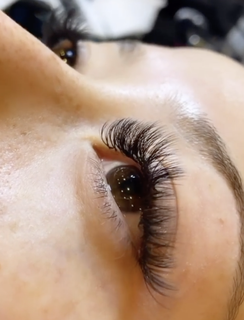 A photograph of a beautiful young woman who has added a Hybrid of Lash extensions to their own natural lashes for a glamorous look. This service was done at Beautify Salon and Spa in Henderson Las Vegas.