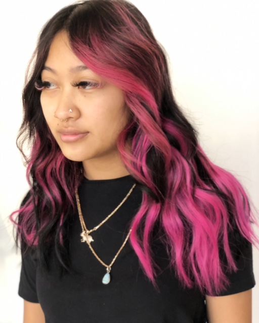 This is a photo of a young lady who has added color and KTip Hair Extensions to her hair for extra volume and a fun pop of pink color. This service was done by Beautify Salon and Spa in Henderson