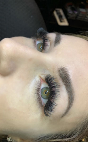 This is a photo of a young woman with lash extensions added to her lashes for extra volume 